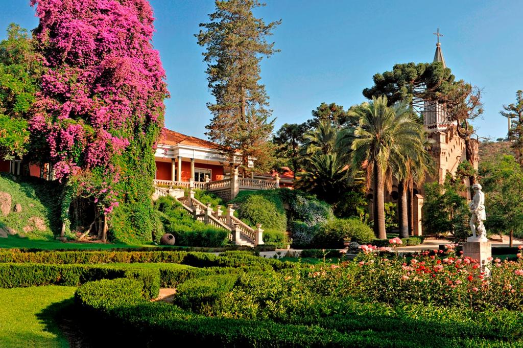 圣地亚哥Hotel Casa Real - Viña Santa Rita的一座带粉红色花卉花园的房屋