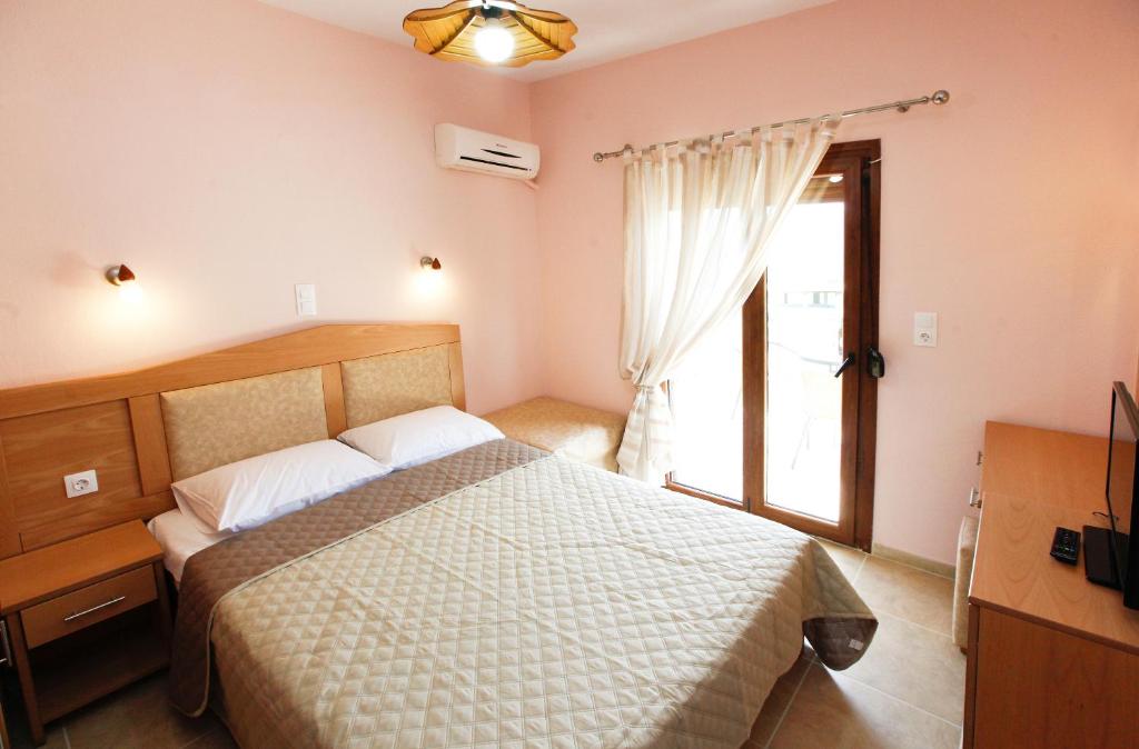 斯卡拉伯塔麦斯Asteras Kalives的一间卧室设有一张大床和一个窗户。
