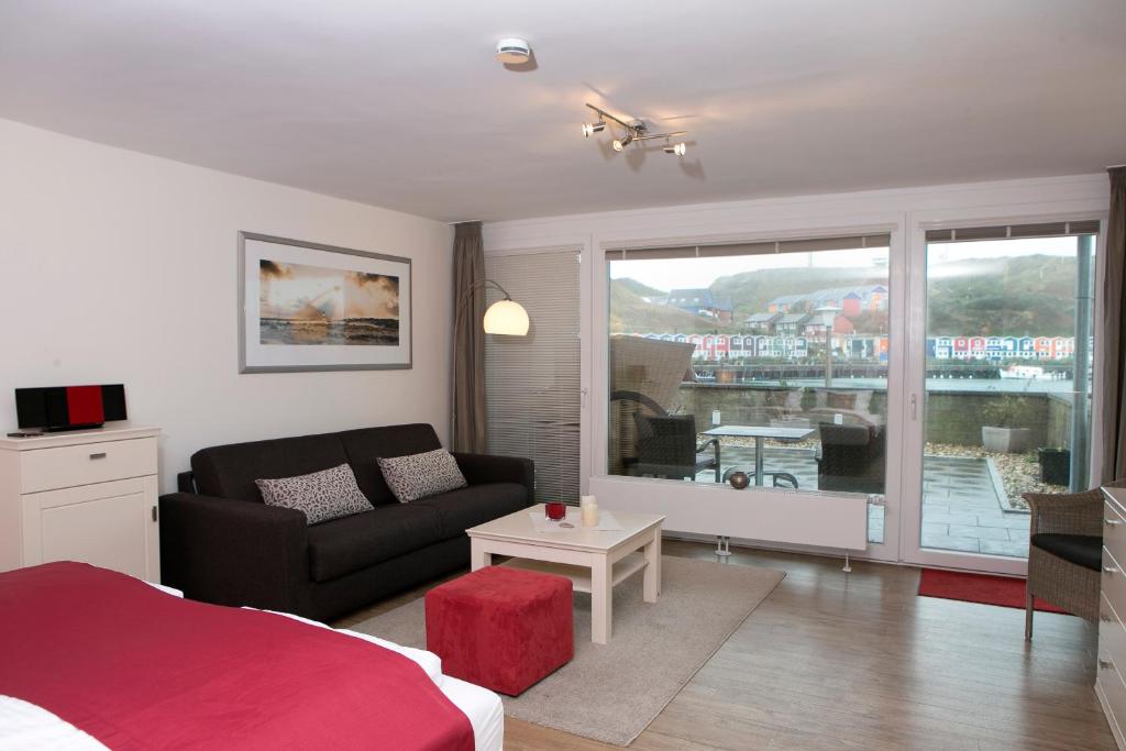 黑尔戈兰岛Appartements am Binnenhafen的一间卧室配有一张床、一张沙发和一个窗口