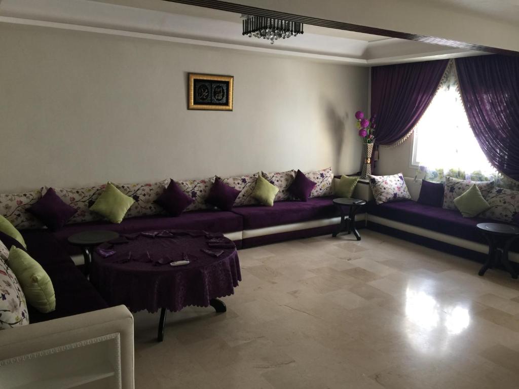 得土安Appartement De Luxe A Wilaya De Tetouan的客厅配有紫色沙发和桌子
