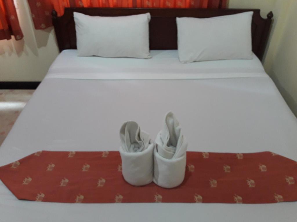 卡塔海滩南方炒饭客栈的一张床上摆着两双鞋的床