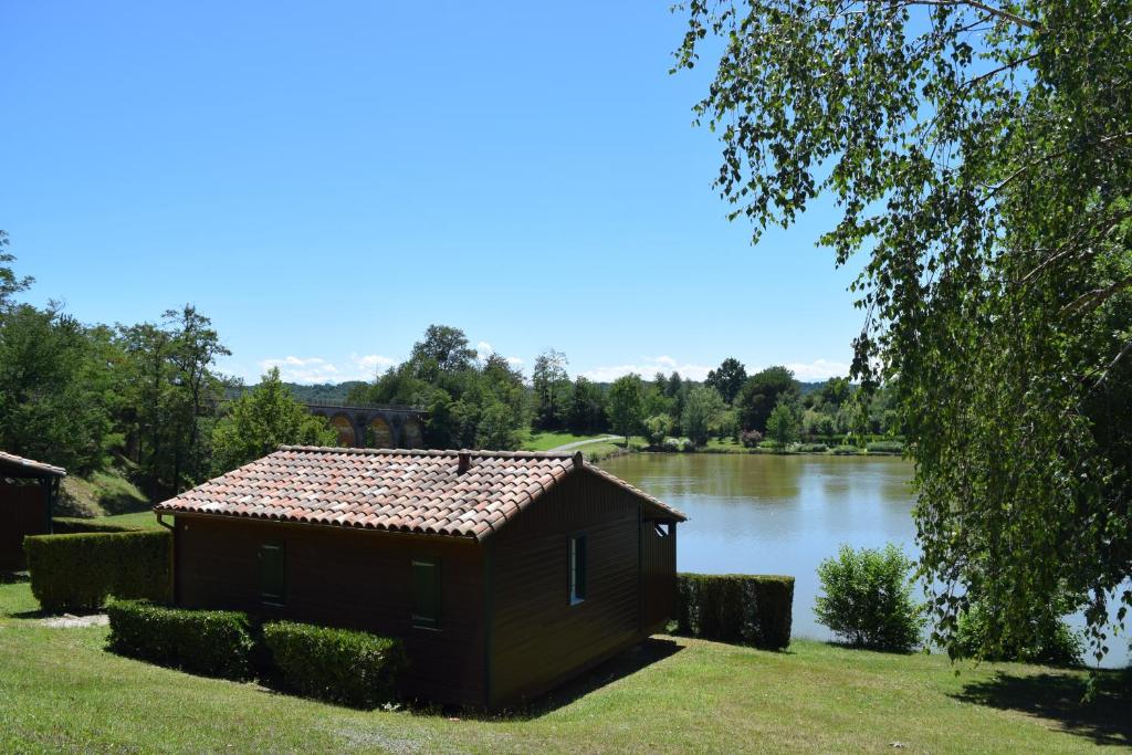 Boulogne-sur-GesseCamping - Village Vacances du Lac的湖畔的小建筑