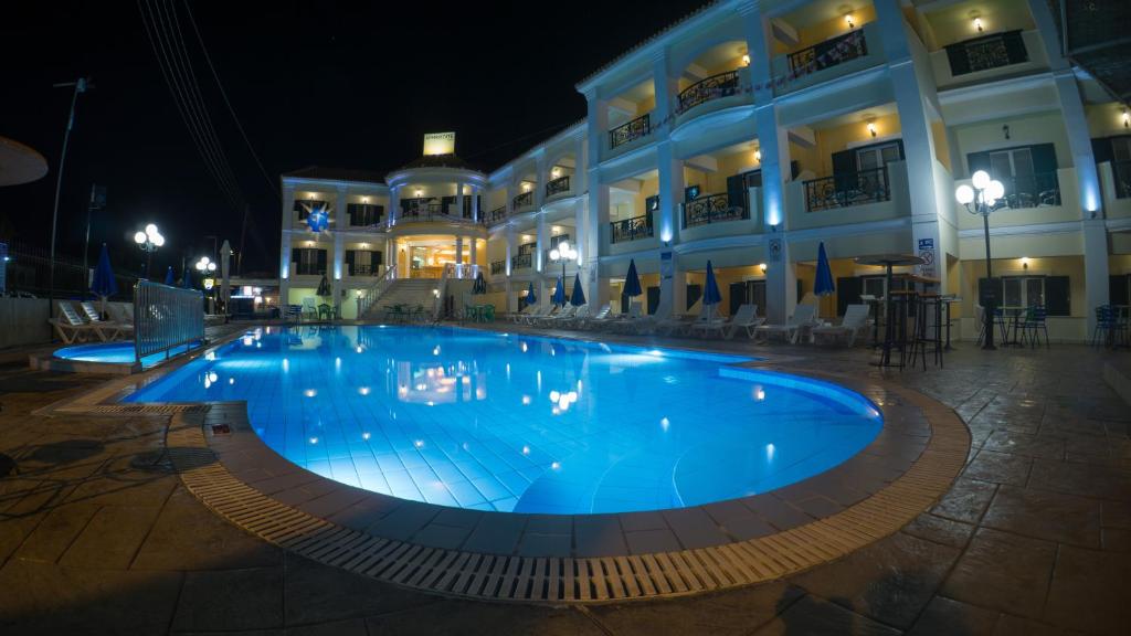 拉加纳斯阿芙罗狄蒂酒店的一座大楼前的游泳池