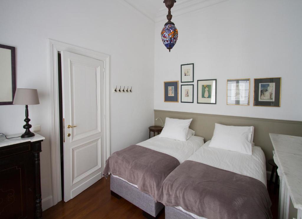 安特卫普Holiday Home Huis Dujardin 3的一间卧室配有两张床和一张带台灯的桌子