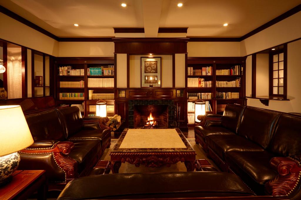 嬉野市汉密尔顿嬉野酒店的客厅配有真皮沙发和壁炉