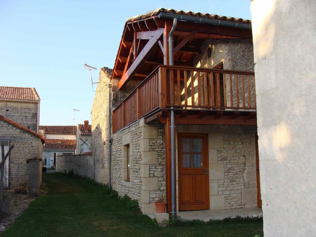 Blanzac-lès-MathaChambre d'hôte Au col de Cygne的一侧设有木制阳台的建筑