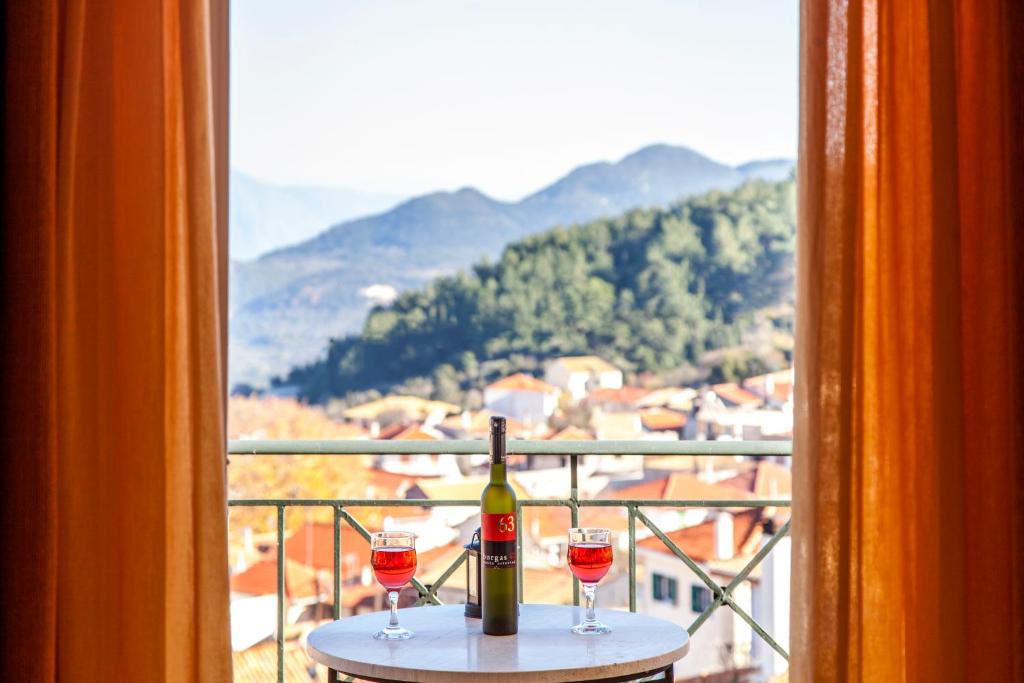 Kariá卡里亚斯一室公寓的窗户前的桌子上放着一瓶葡萄酒和两杯酒