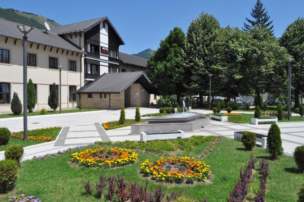 Andrijevica科莫维酒店的一座公园,在一座建筑前面的草地上种满鲜花
