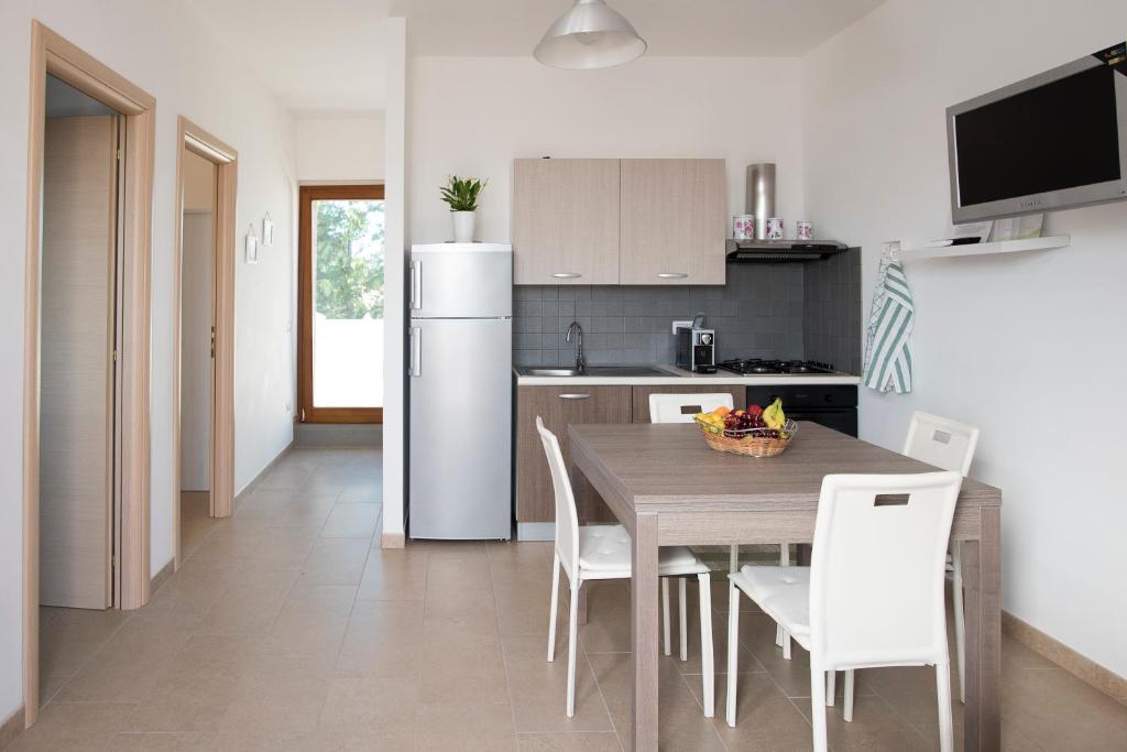 皮斯蒂奇Il Delfino的厨房配有桌椅和冰箱。