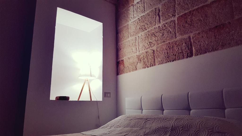 滨海波利尼亚诺La Maison A La Mer的一间卧室设有一张床和砖墙