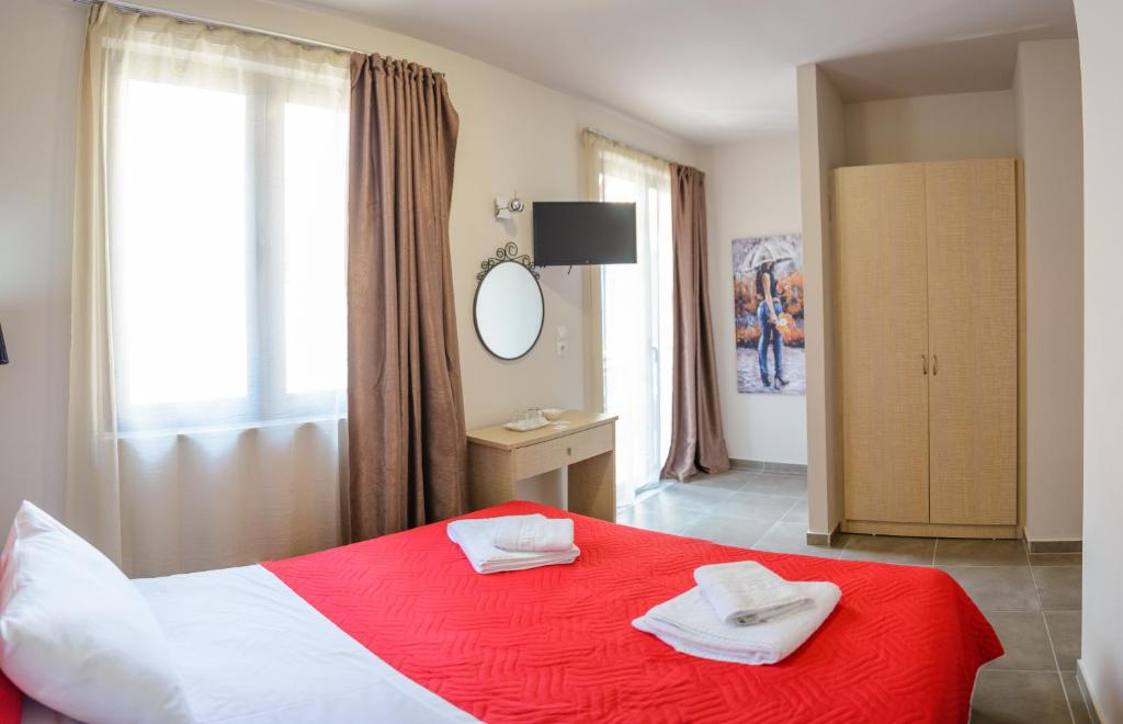 比雷埃夫斯LUX Hotel的卧室配有红色和白色的床和镜子