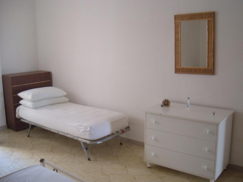 莱乌卡Appartamento Lucio Leuca的一间卧室配有一张床、梳妆台和镜子