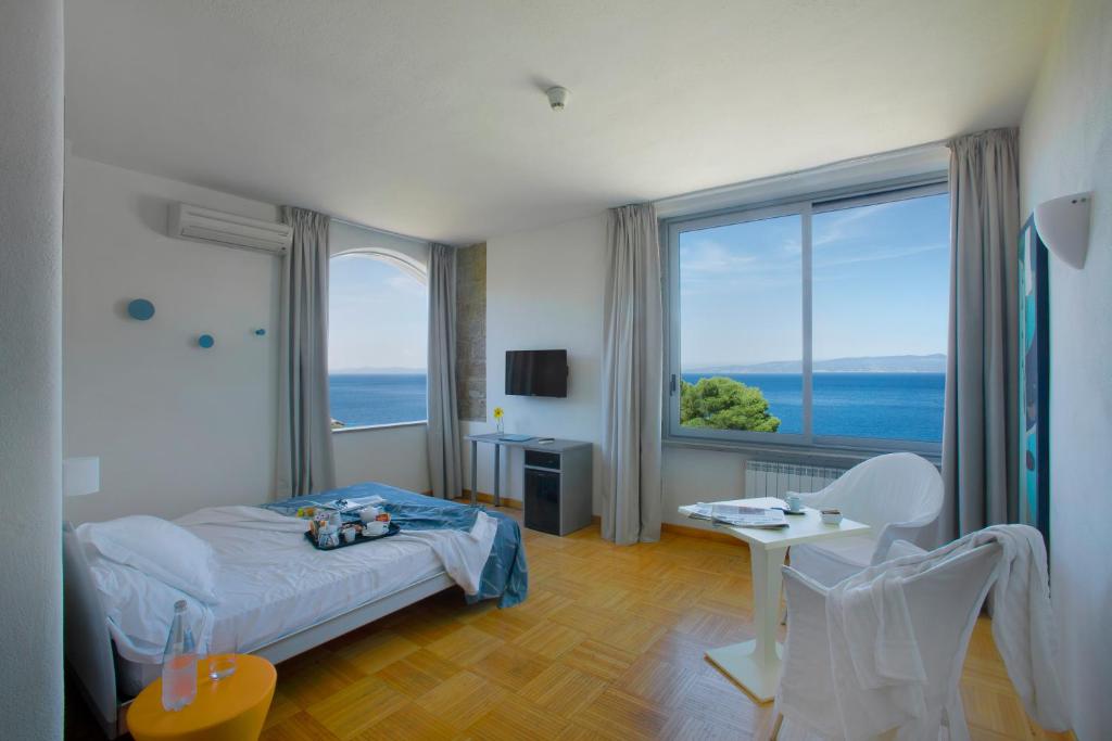 吉廖港阿雷内拉酒店的一间卧室设有一张床和一个大窗户