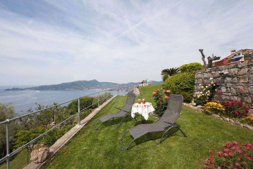 基亚瓦里Rosso su Portofino的坐在水边的草上,桌子和椅子
