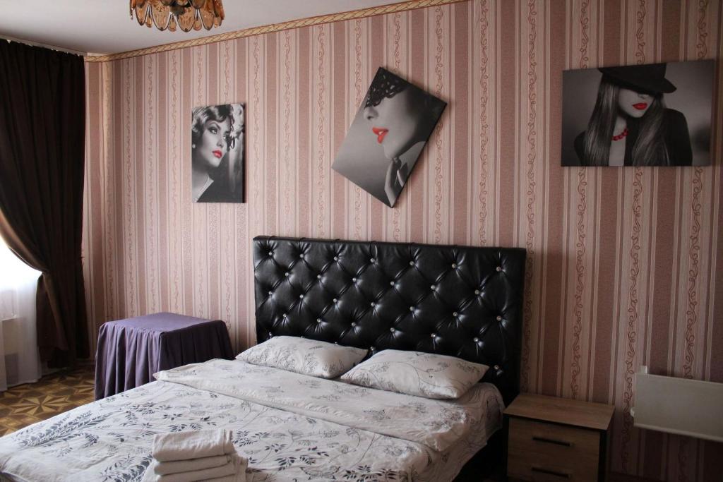 白采尔科维Apartment on Fastivs'ka 2的卧室配有一张床,墙上挂有图片