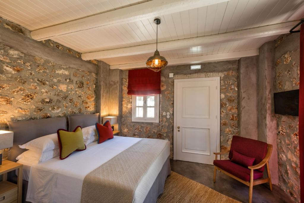 FroúrionNorth Point Rooms的一间卧室配有一张床和一张红色椅子
