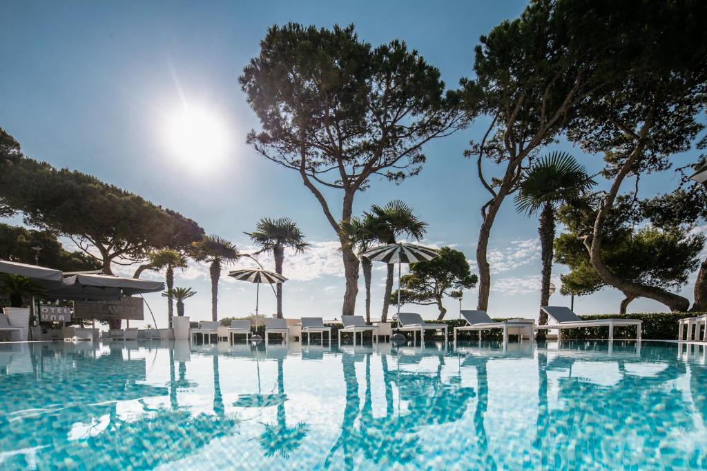 利尼亚诺萨比亚多罗贝拉维斯塔酒店的一个带椅子和遮阳伞的游泳池