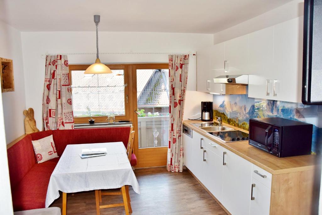 奥贝劳埃斯托利亚公寓酒店的一间带红色沙发和桌子的小厨房