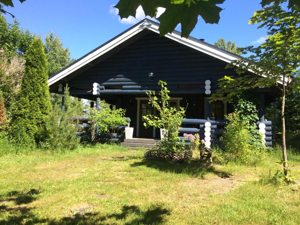 鲁奥科拉赫蒂Kallioranta Cottage的前面有院子的黑色房子