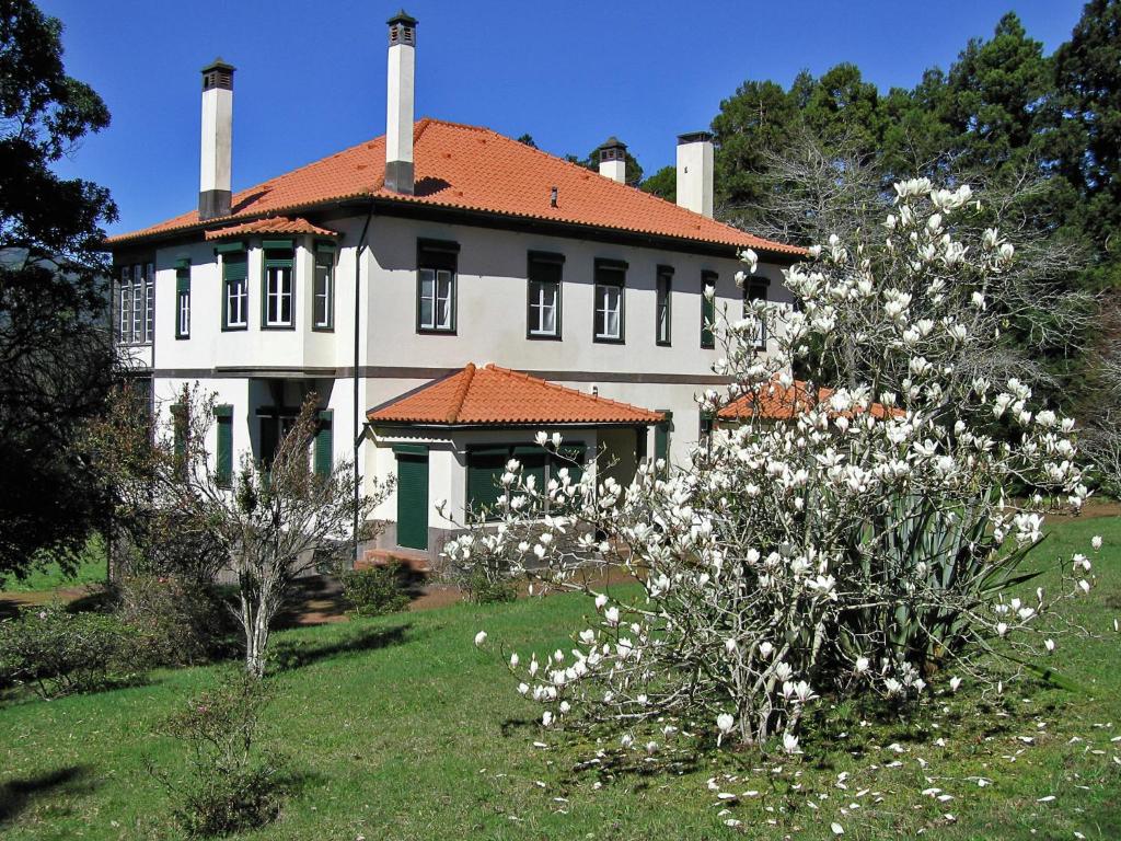 圣达塞拉Beautiful house on the garden island of Madeira的前面有白色花的大房子