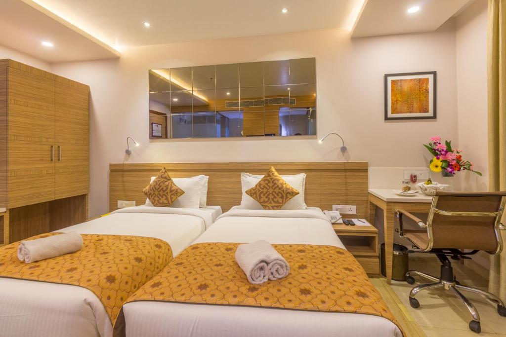 古瓦哈提Hotel Palacio的酒店客房配有两张床和一张书桌