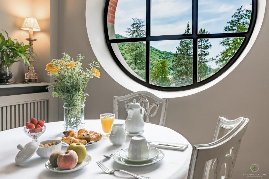 贝桑松Hôtel Restaurant Spa Le Sauvage的一张桌子,上面放着一盘食物,还有一个圆窗