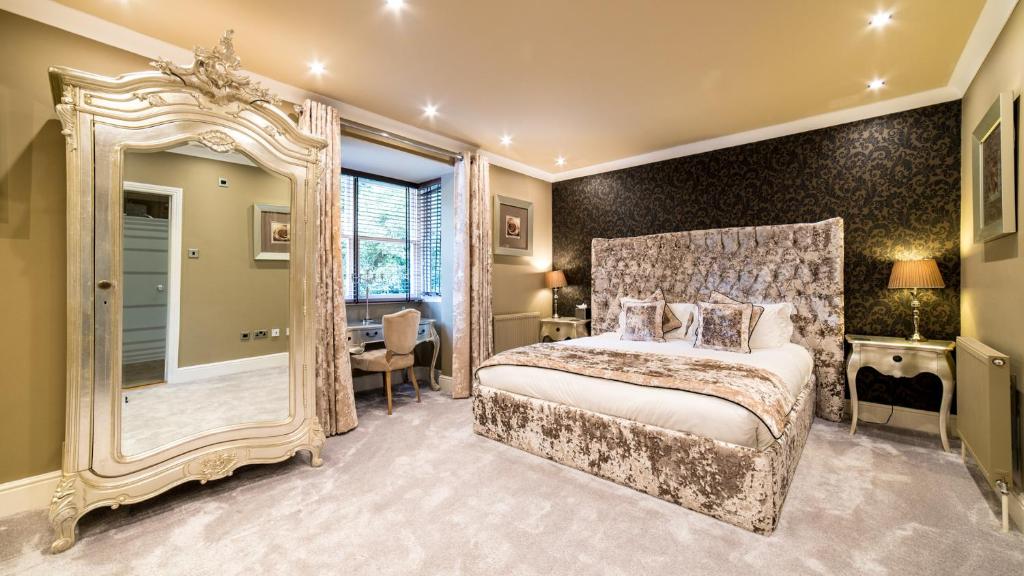 伯恩茅斯Derby Manor的一间带大镜子和床的卧室