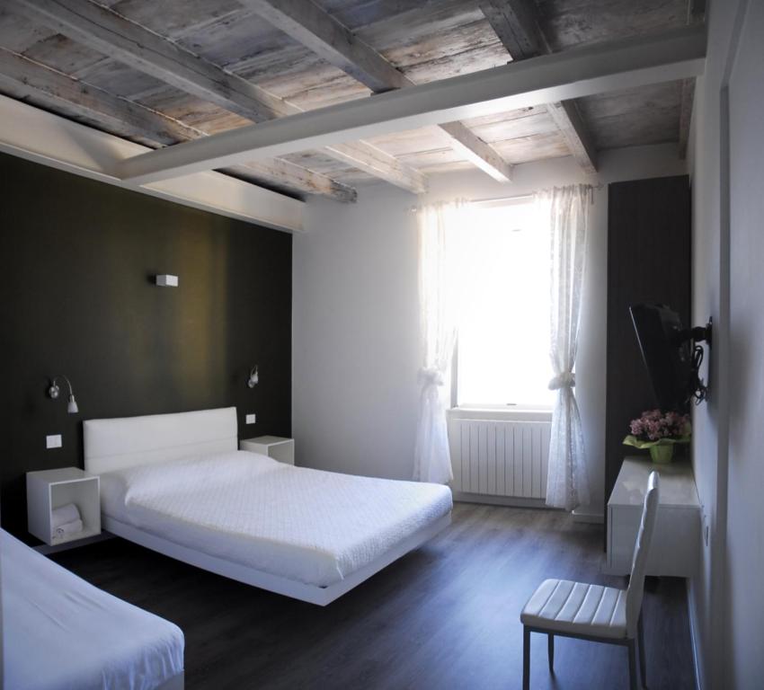Castro伊塞奥湖住宿加早餐旅馆的卧室配有白色的床和窗户。