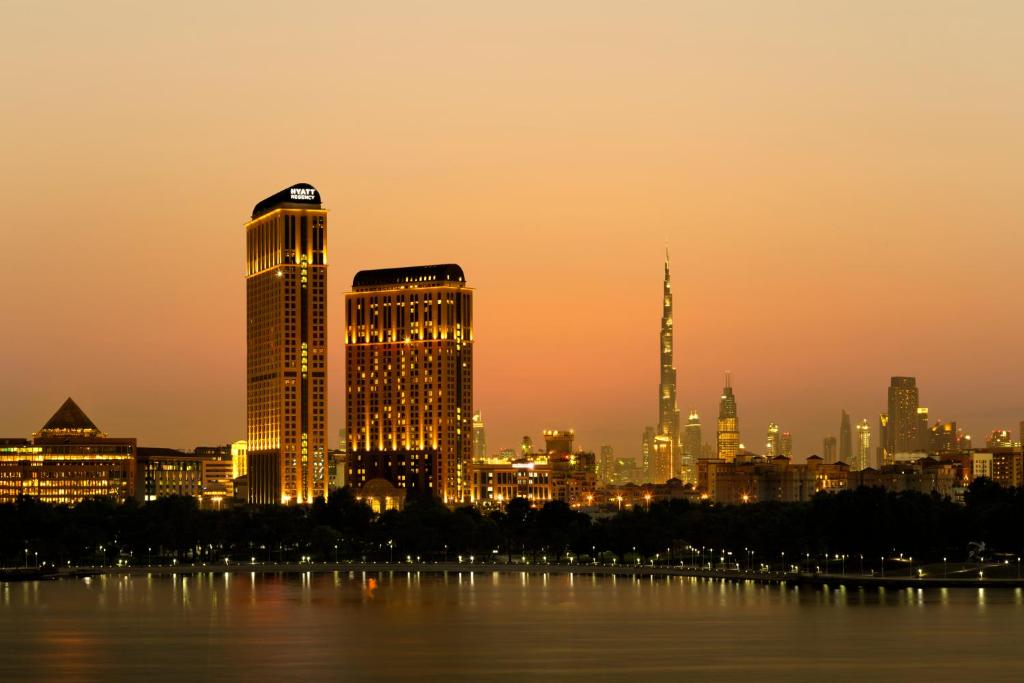 迪拜克里克高地凯悦公寓式酒店的日落时分享有城市天际线的景致