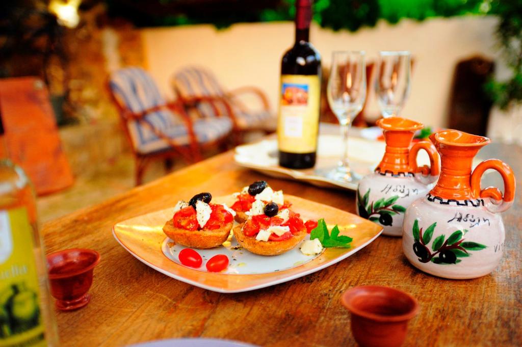 帕诺尔莫斯雷斯蒙伊蒂利酒店的一张桌子,上面放着一盘食物和一瓶葡萄酒