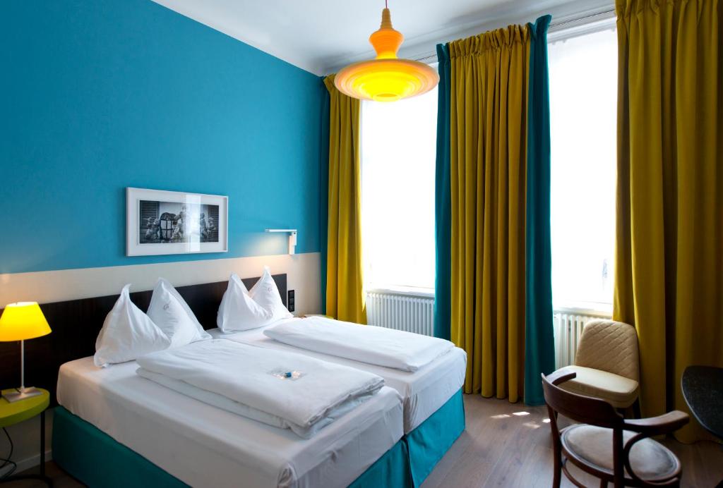 维也纳维也纳贝多芬酒店的酒店客房,设有一张蓝色墙壁的大床