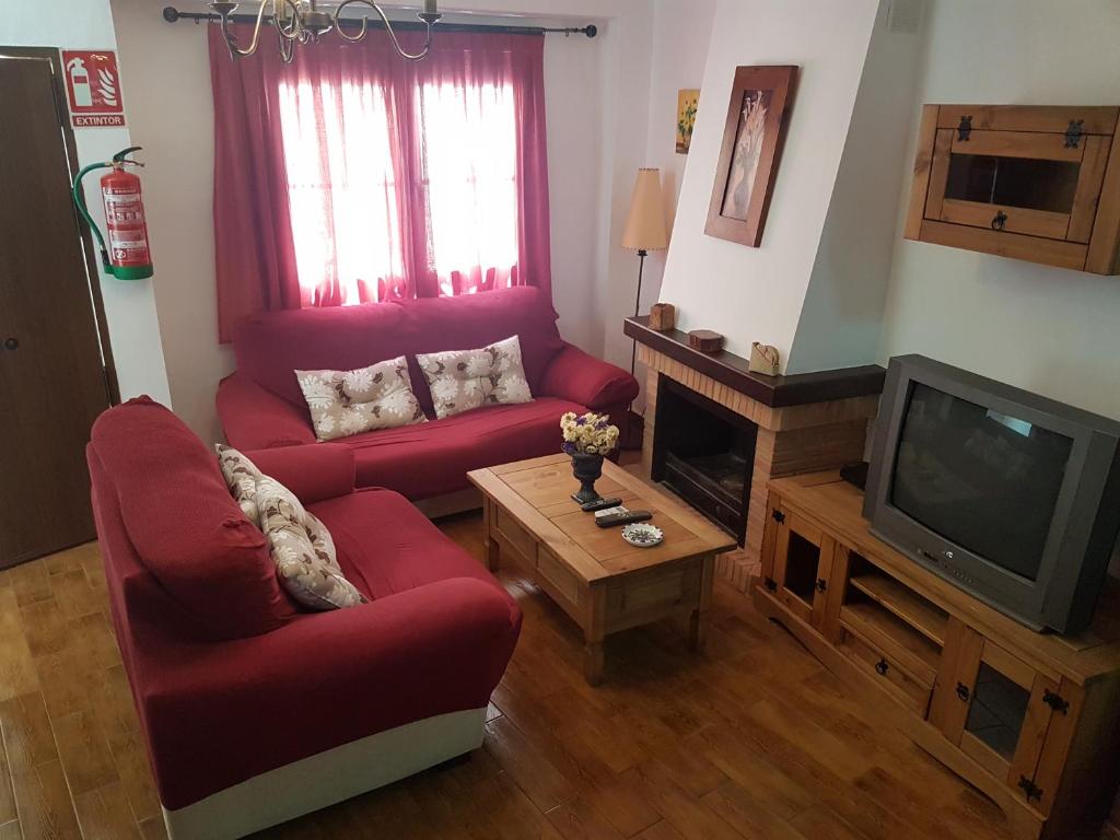 科尔特斯德拉夫龙特拉念珠度假屋的客厅配有2把红色椅子和电视