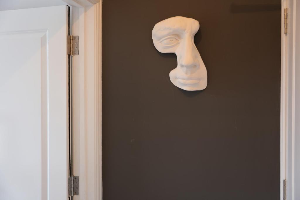 伦敦Marleybone Victorian Apartment的挂在门边墙上的面具