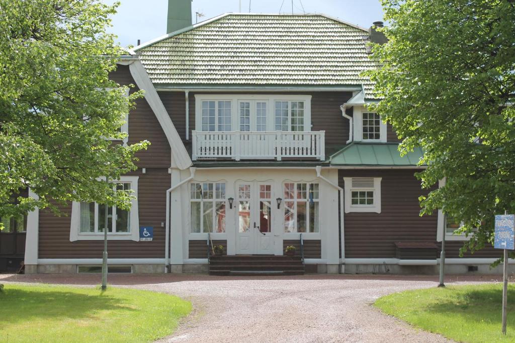 奥萨Trunna Vandrarhem & Konferens的一间棕色的房子,设有白色的门和窗户