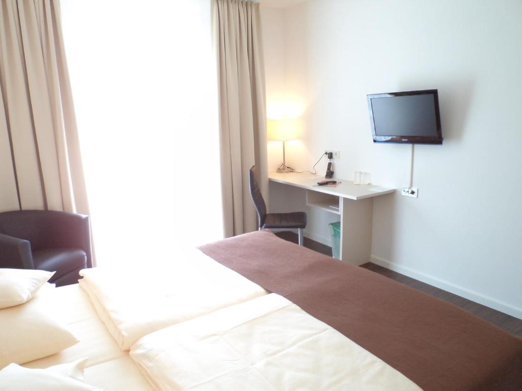弗伦登贝格达斯纽公园酒店的酒店客房配有一张床和一张书桌及一台电视