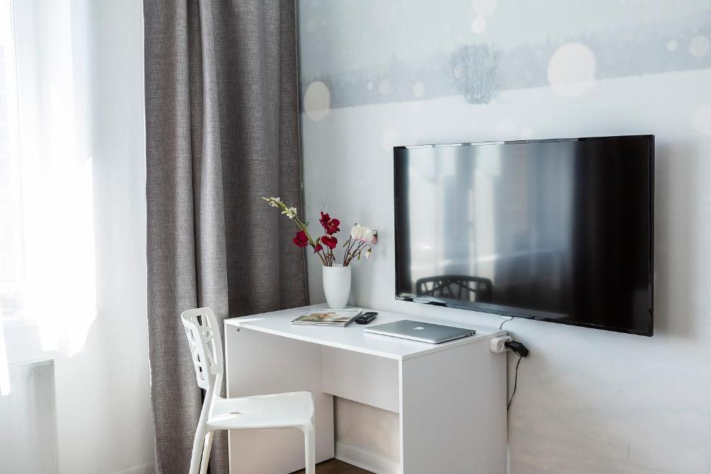 伊尔库茨克市中心欧丁公寓的一张白色的桌子,墙上有电视