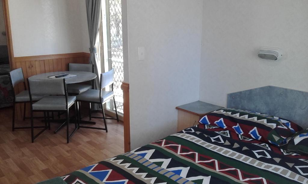 诺斯曼阿克雷休闲旅游公园酒店的一间卧室配有一张床和一张桌子及椅子