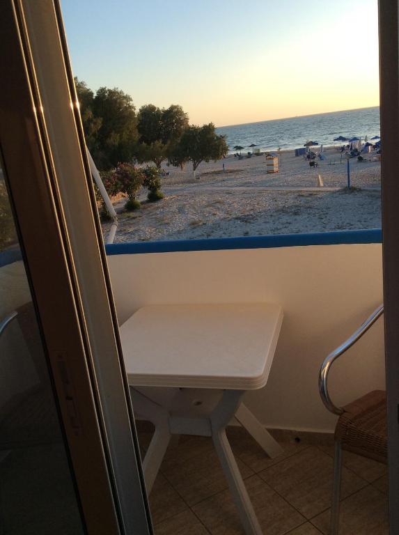 马斯蒂查里Katerina & Efi Apartments的窗户享有海滩美景,设有长凳