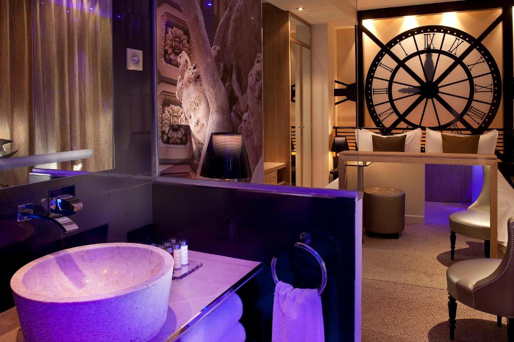 巴黎Secret de Paris - Hotel & Spa的浴室配有水槽和墙上的大轮子