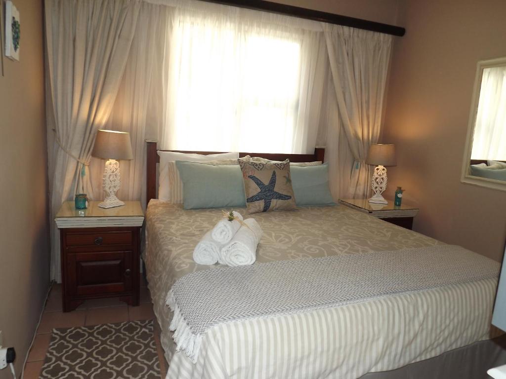 乌姆科马斯Stroke-One-Inn的一间卧室配有一张带两盏灯的床和一扇窗户。