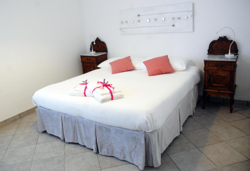 CastelnuovoB&B La Montagna Rosa的白色的床和红色和白色的枕头