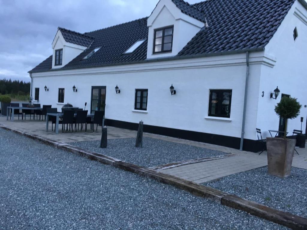 EngesvangHedegaarden的前面设有桌椅的白色房子