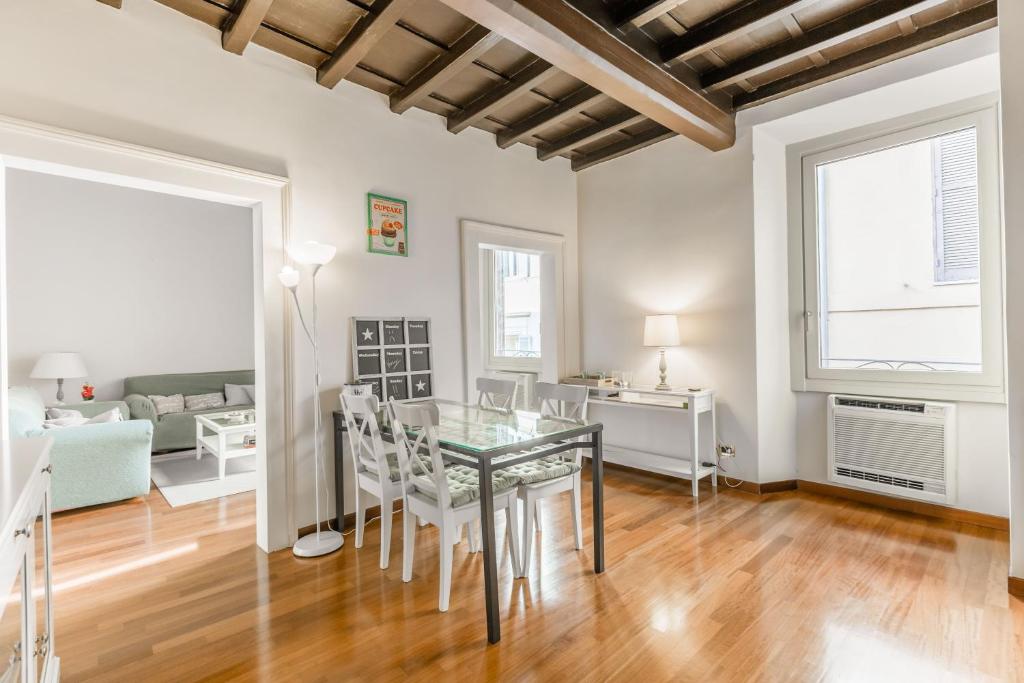 罗马Navona Bernini Lodge的一间设有玻璃桌和白色椅子的用餐室