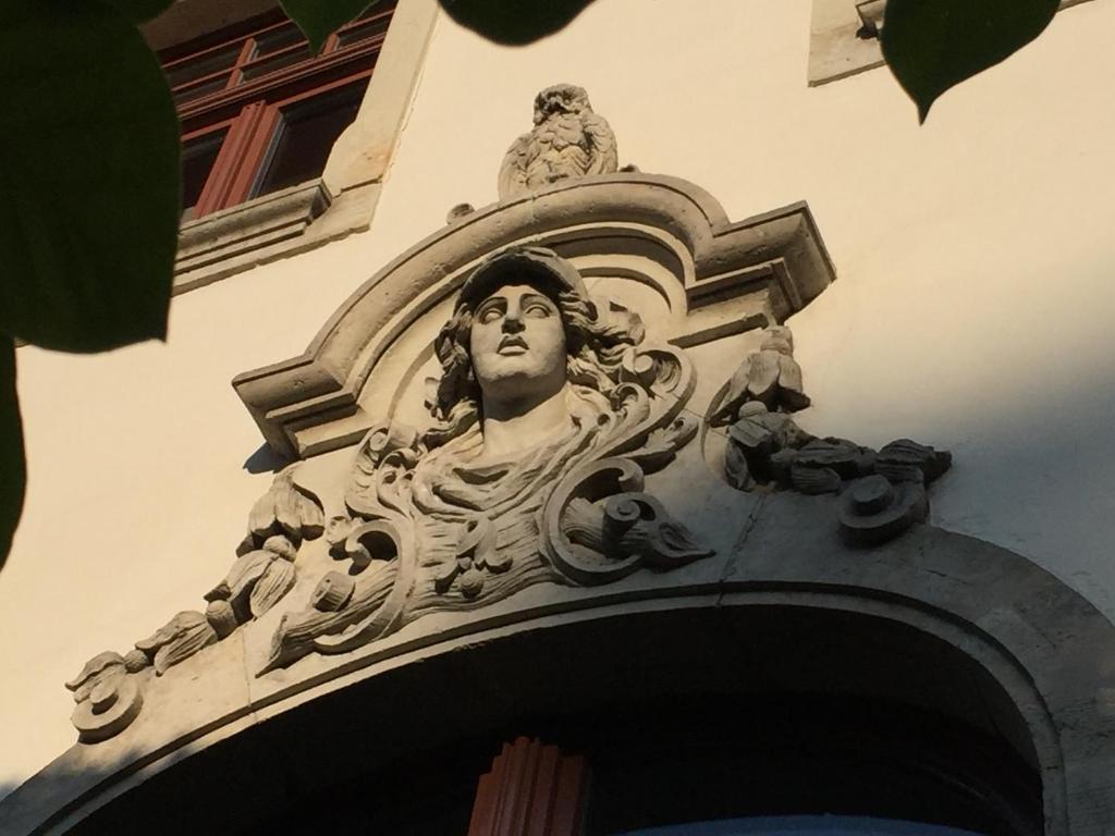德累斯顿Villa am Grossen Garten的建筑物一侧的男人雕像