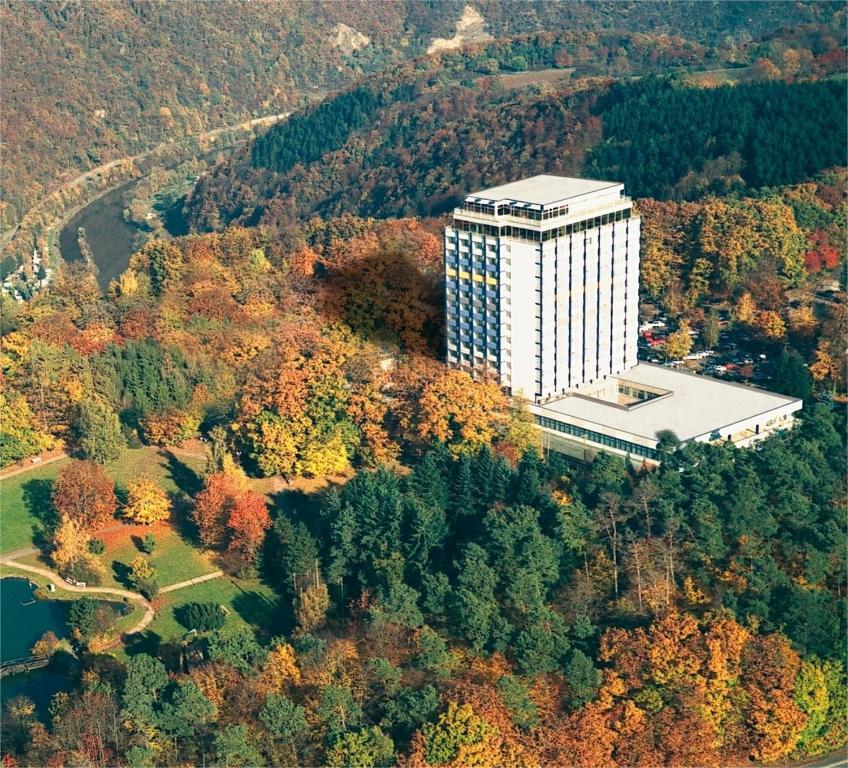 兰施泰因温德姆花园拉恩斯坦科布伦茨酒店的森林中间高大的白色建筑