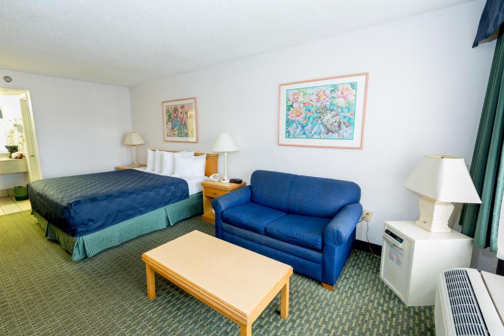 奥兰多梅因盖特湖边度假酒店的酒店客房,配有床和蓝色的沙发