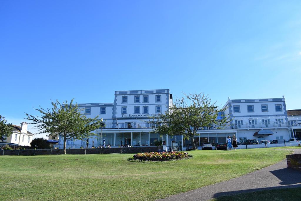 托基巴巴科姆酒店的一座白色的大建筑,前面有一个公园