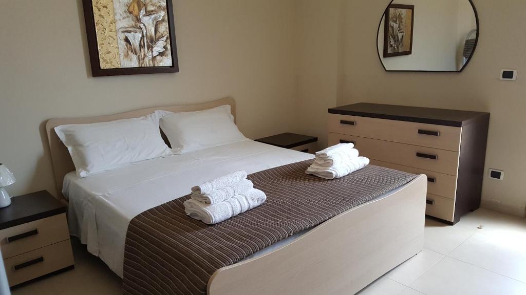 玛丽娜迪曼卡维萨Appartamenti Emblema Mancaversa的一间卧室配有带毛巾的床