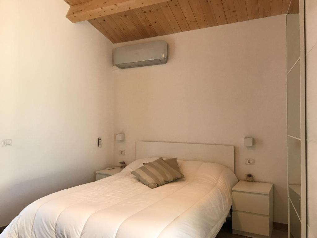 维贾内洛Affittacamere Al Civico 18的卧室配有白色床和木制天花板