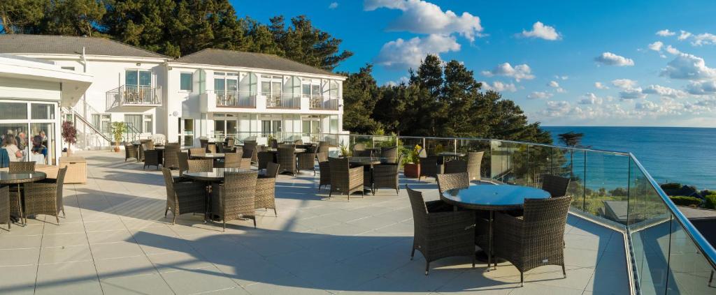 圣布雷拉德比亚里茨酒店 的一个带桌椅的庭院和大海